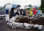 下布田6号墳（狐塚古墳）で行われた見学会で、参加者が奥壁の切石を見学しているところです。