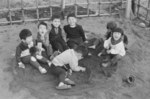 「ちびっこ広場」は国立市が空き地を借用し、砂場や鉄棒などを設置した子どもの遊び場でした。都市化の進展や交通事故の危険に対し、保護者の声が届くような近くに、小さな遊び場をつくることを目的としていました。<br />
写真は、昭和42（1967）年、はじめに7カ所完成したちびっこ広場のひとつで遊ぶ子ども達をとらえています。砂場で遊ぶ子ども達が楽しそうに笑顔を向けた、とても素敵な1枚ですが、翌年（昭和43・1968年）正月号の市報トップに大きく掲載された写真です。<br />
